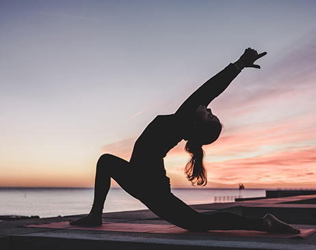 Woman doing yoga at sunset