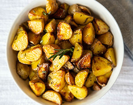 Roasted potatoes with a sprig of Rosemary